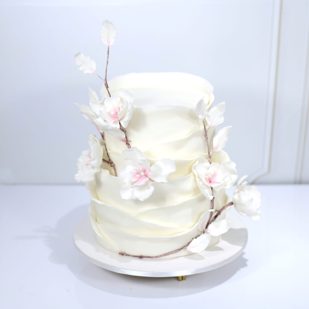 Delicate Cherry Blossom Engagement Cake, with hand-painted floral designs and cascading sugar blossoms, capturing the beauty of spring.