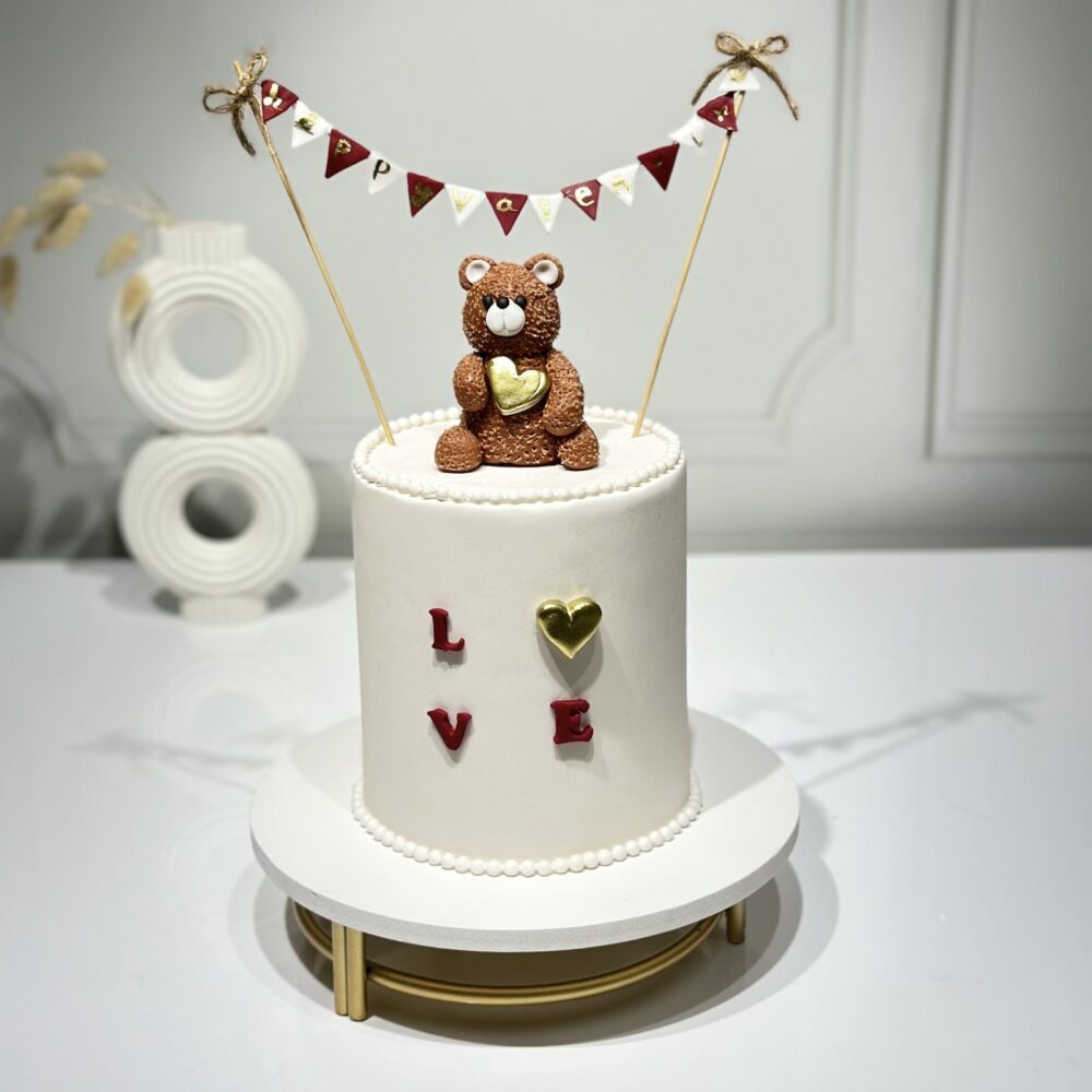 Custom Valentine's Day cake featuring a chocolate bear on top, perfect for couples - Pink Cakes Valentine's Collection.